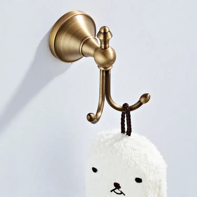 Antique brass double hook towel rack with textured finish and ornate detailing in decorbites bronze bathroom set
