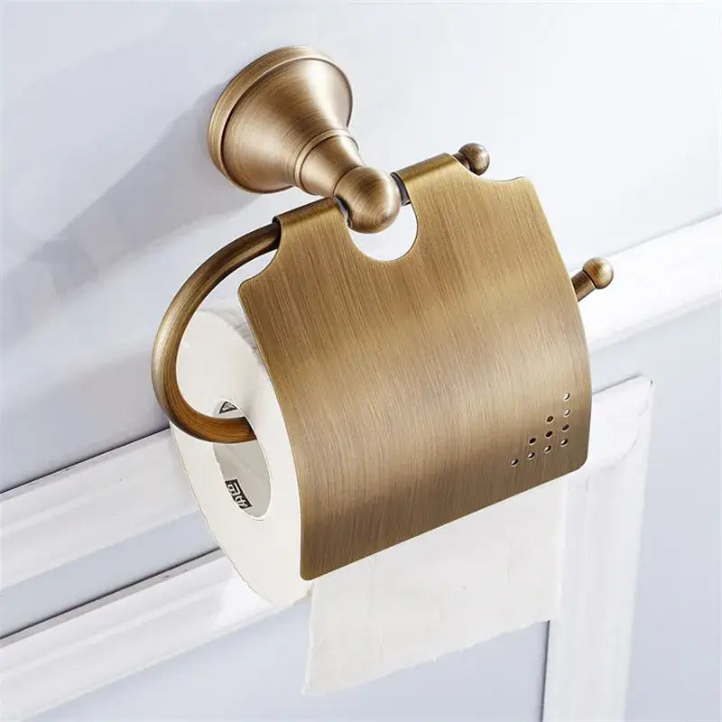 Antique brass-finished toilet paper holder with brushed surface and decorative spheres in bronze bathroom accessories set