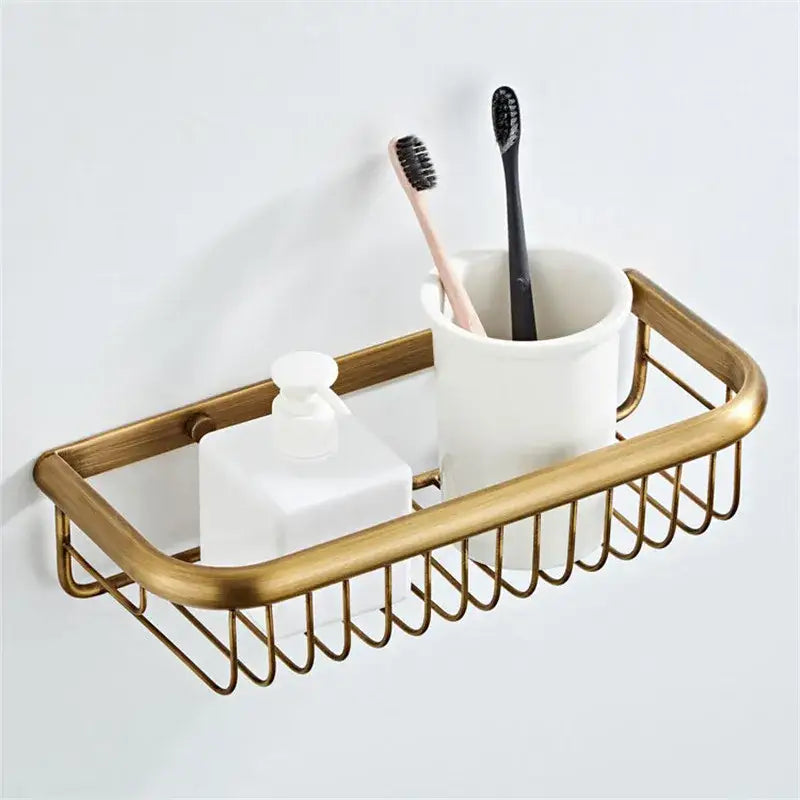 Bronze and white ceramic bathroom accessories set with gold-toned wire caddy holding ceramic cup and frosted soap dispenser