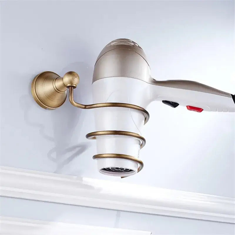 A sleek white and metallic hair dryer mounted on a brass wall bracket with spiral rings from decorbites bronze bathroom accessories set