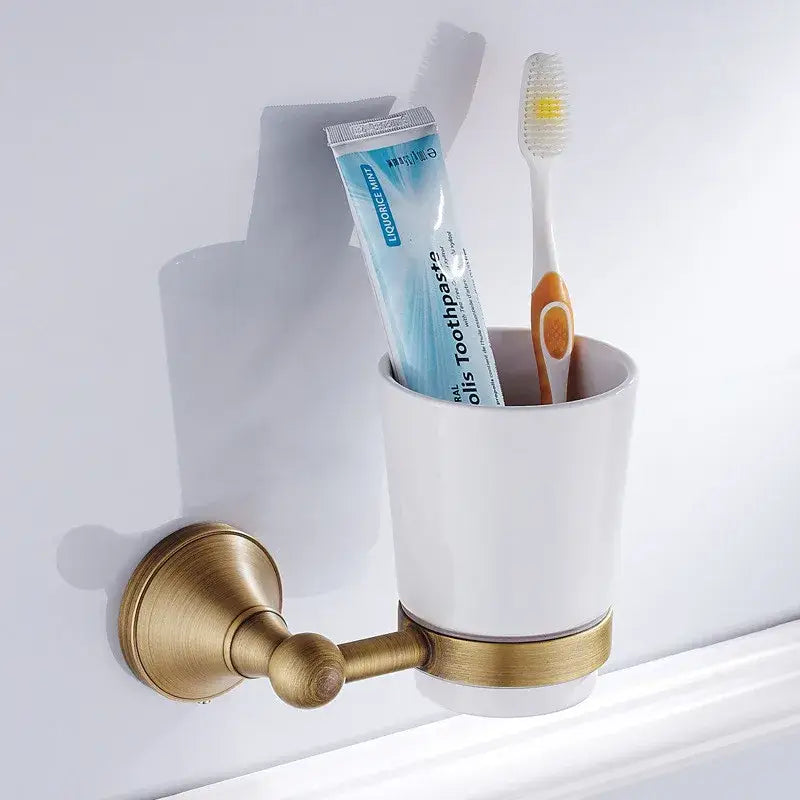 White ceramic toothbrush holder with brass metal bracket and accent band from decorbites bronze bathroom accessories set