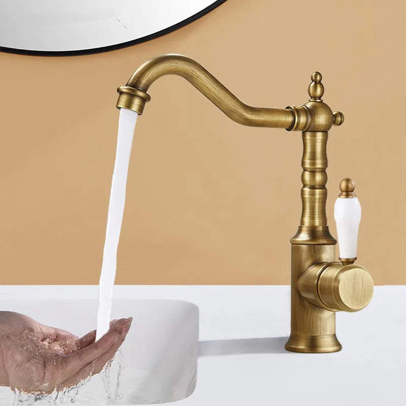 Antique brass-finished bronze basin faucet with white ceramic handle designed for cold water deck mounting