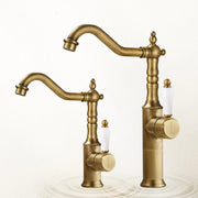Antique brass bronze basin faucet with white ceramic handles and ornate design for cold water deck mounting