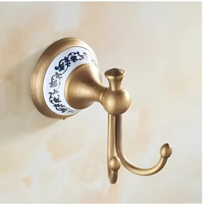 Antique brass bathroom hook with white ceramic base and blue floral patterns from decorbites bronze bathroom hardware set