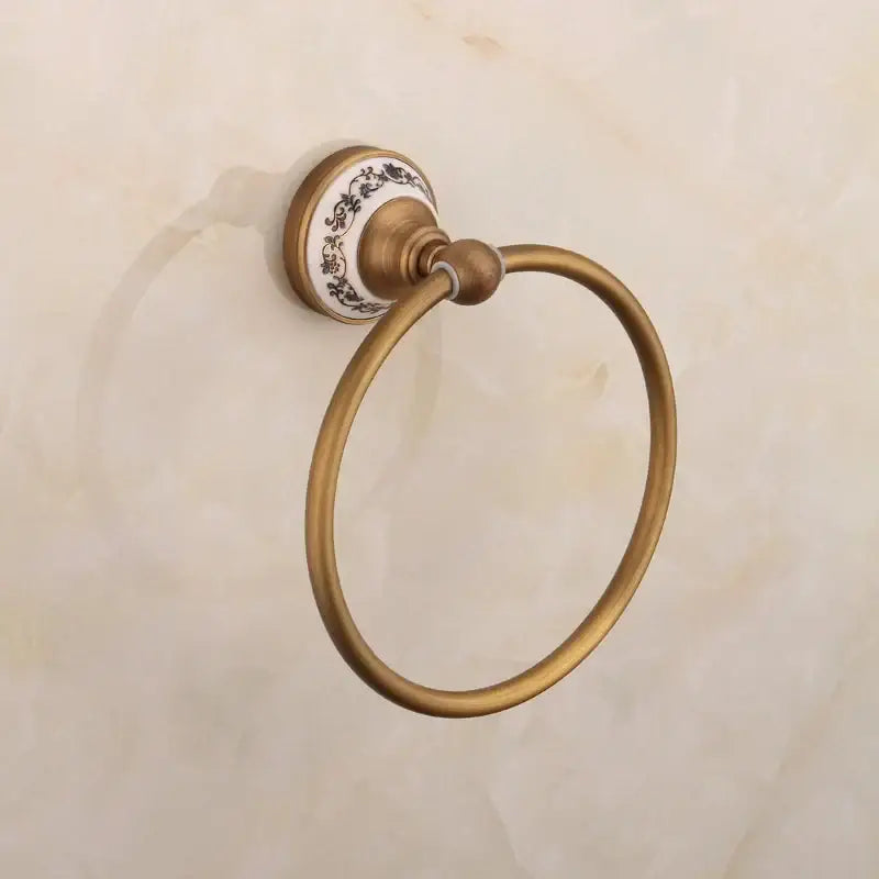 Antique brass towel ring with decorative white ceramic backplate featuring black floral patterns from decorbites bronze bathroom hardware set