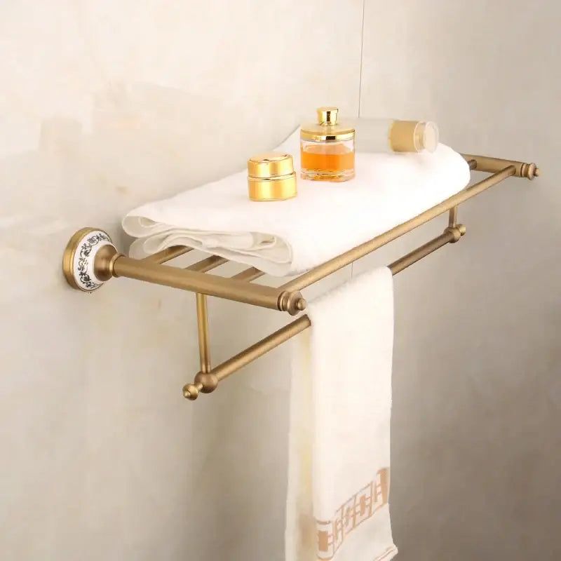 Bronze bathroom hardware set featuring brass towel rack with ceramic decorative mounts and dual bars holding a white towel
