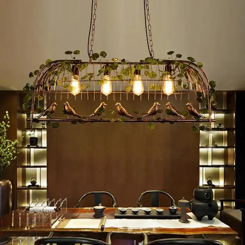 Bronze decorbites birdcage pendant lights with five glowing bulbs decorative birds and green leafy garland for dining room decor