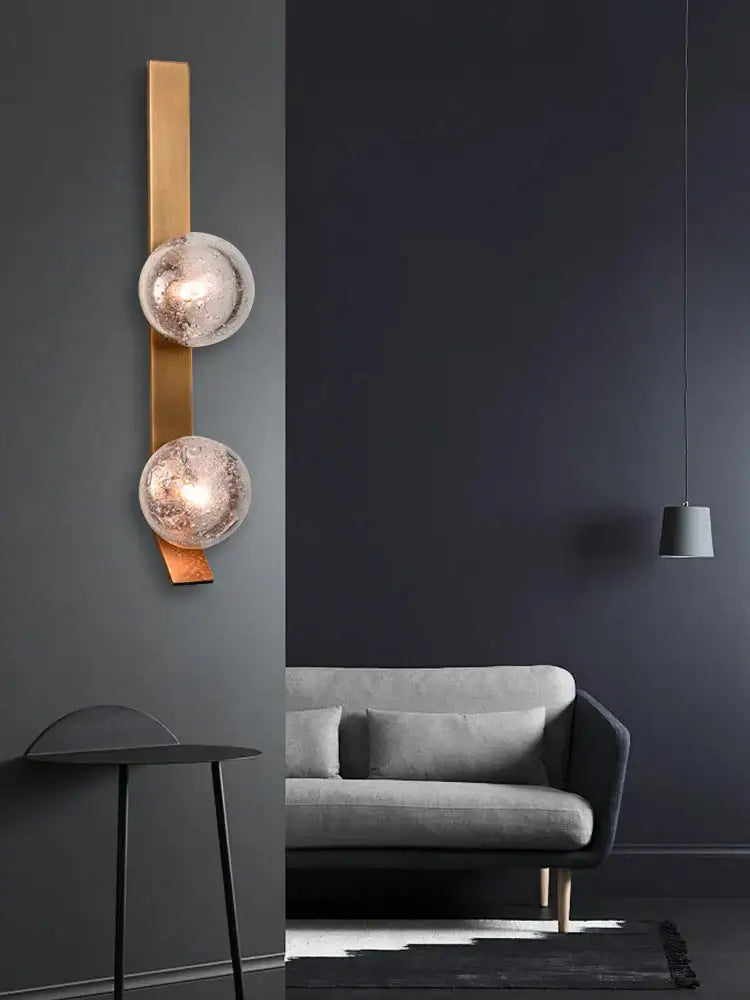 Gold-toned bronze bubble glass wall sconce lamps with two frosted glass globe shades for bedroom use