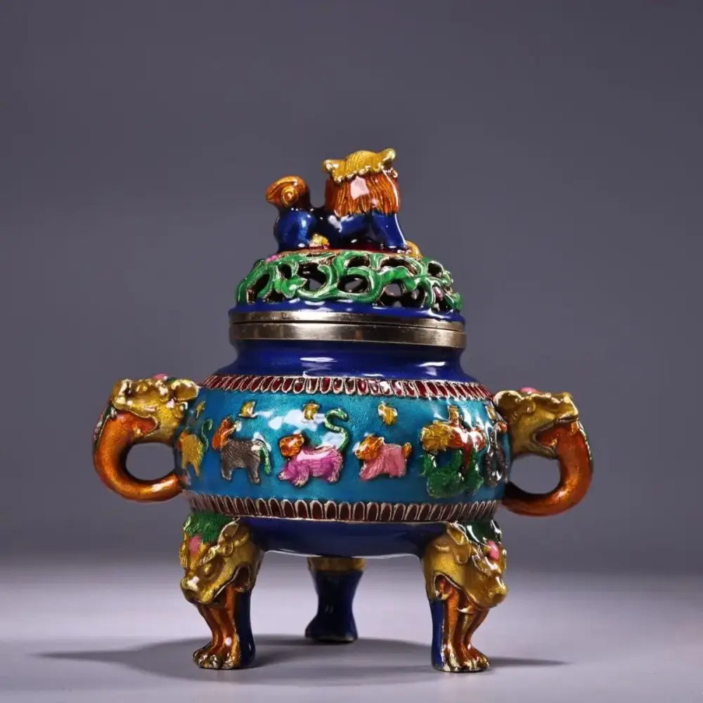 A vibrant blue and gold bronze cloisonne lion incense burner with intricate animal motifs and dragon handles for decorbites decor