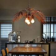 Bronze coconut tree pendant lamp with bronze-colored metal leaf design and three exposed bulbs for dining room decorbites bronze coconut
