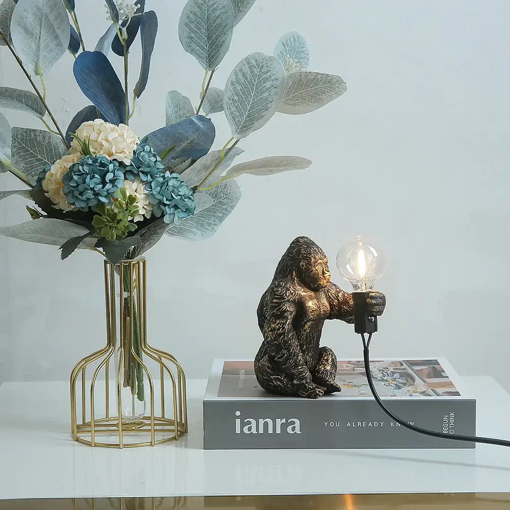 Bronze king kong gorilla table lamp with visible filament bulb held in hand for bedroom night light use