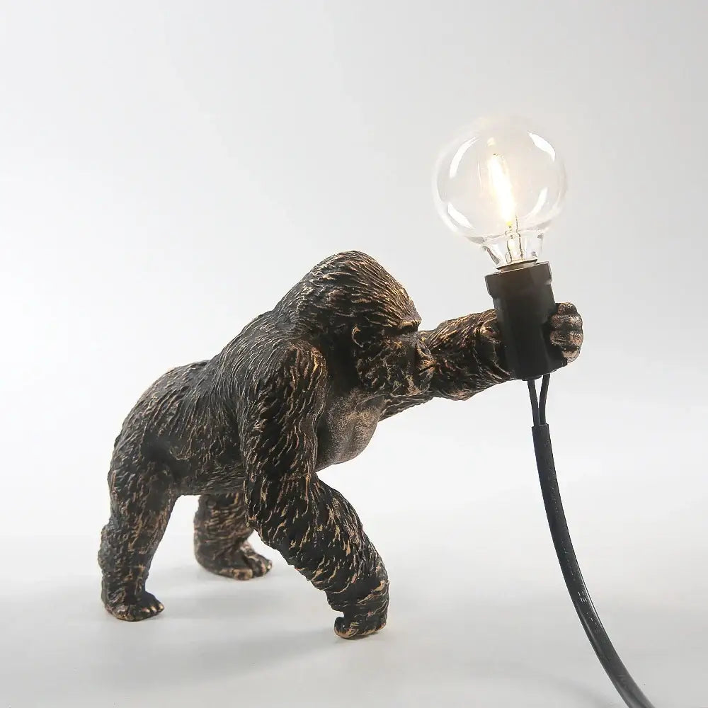 Bronze king kong gorilla table lamp with textured fur holding a clear bulb perfect as a bedroom night light