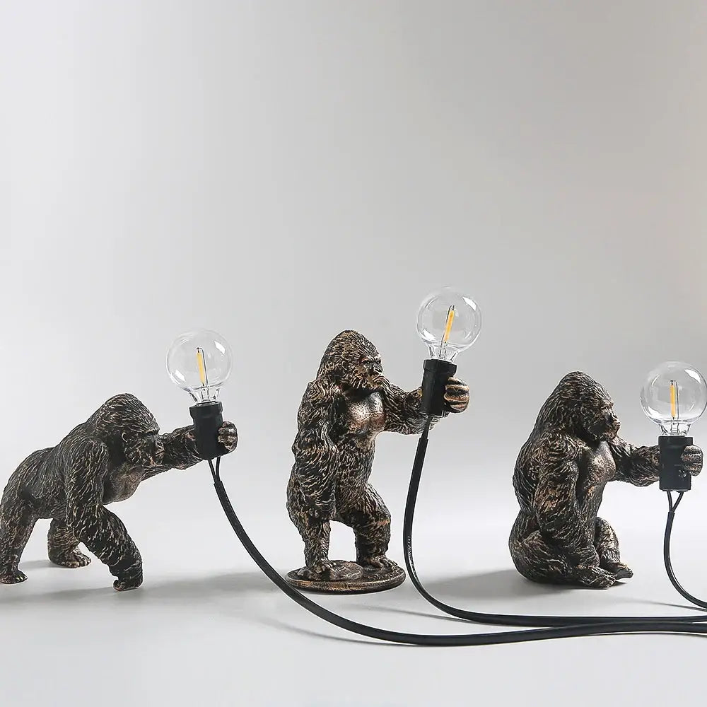 Bronze king kong gorilla table lamp featuring three bronze-finished gorilla figurines holding glass edison bulbs