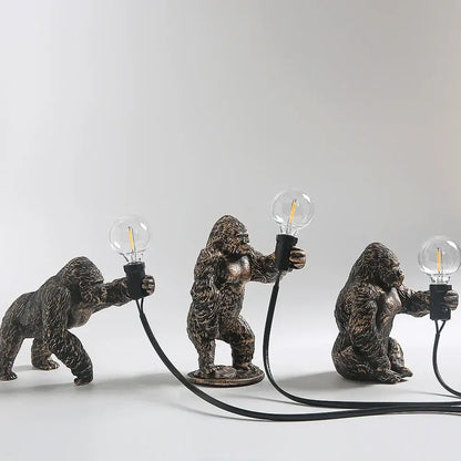 Bronze king kong gorilla table lamp featuring three bronze-finished gorilla figurines holding glass edison bulbs