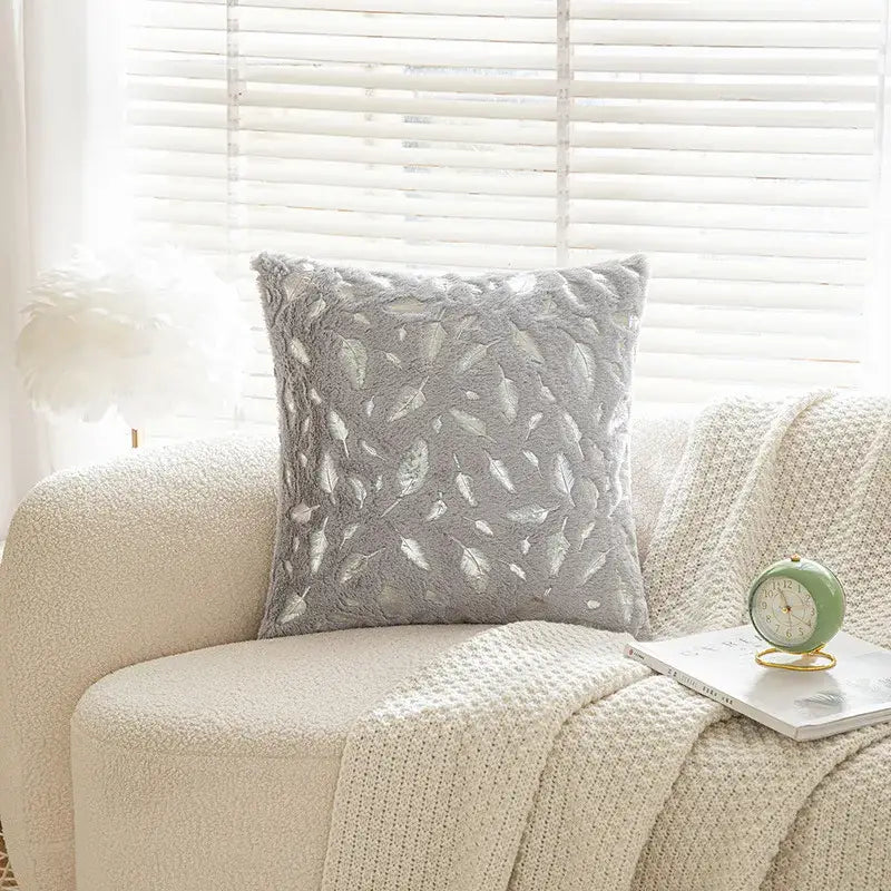 Gray plush throw pillow with textured leafy pattern in lighter gray and silver tones for bronzed feather style decor