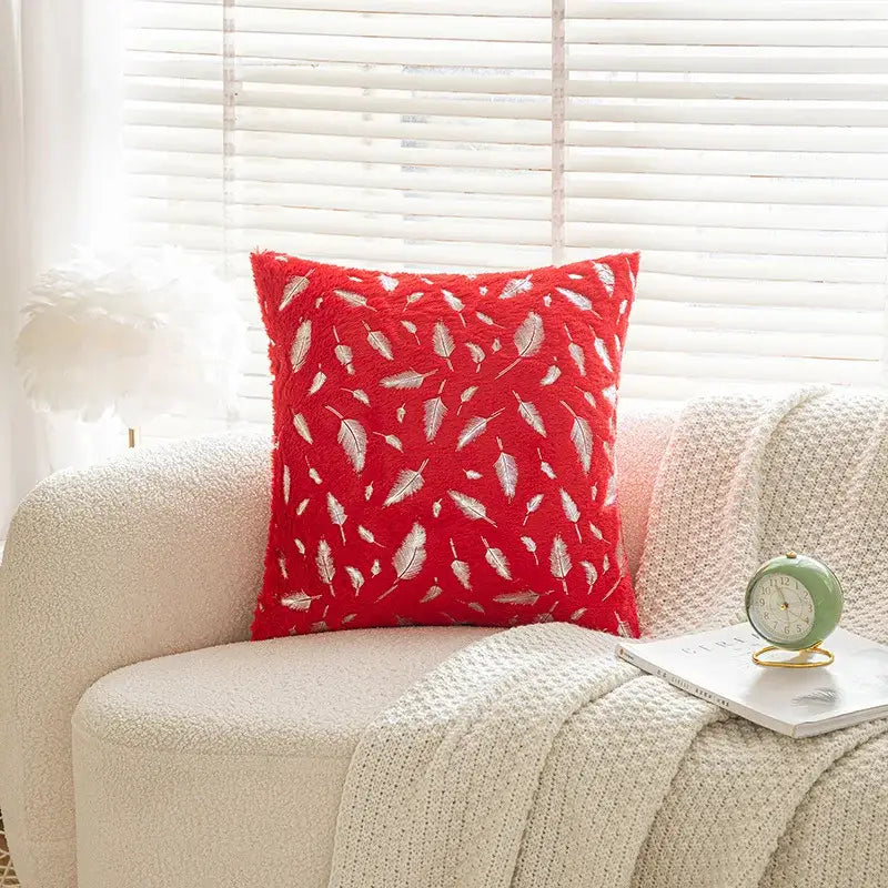 Red plush throw pillow with white feather embroidery featuring bronzed feather style for living room decor