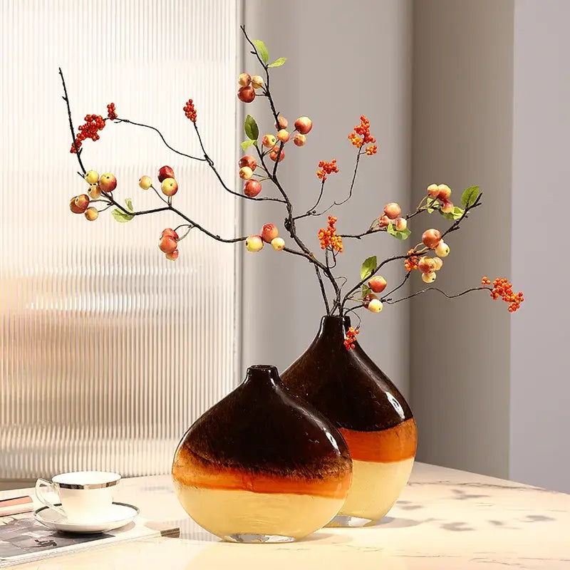 Two glossy ceramic gradient glass vases in brown and cream with red berries and small apples for home decor