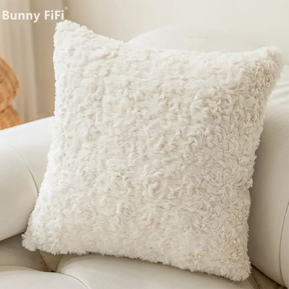 White fluffy plush cushion cover with textured curly surface and brown and white geometric embroidery design
