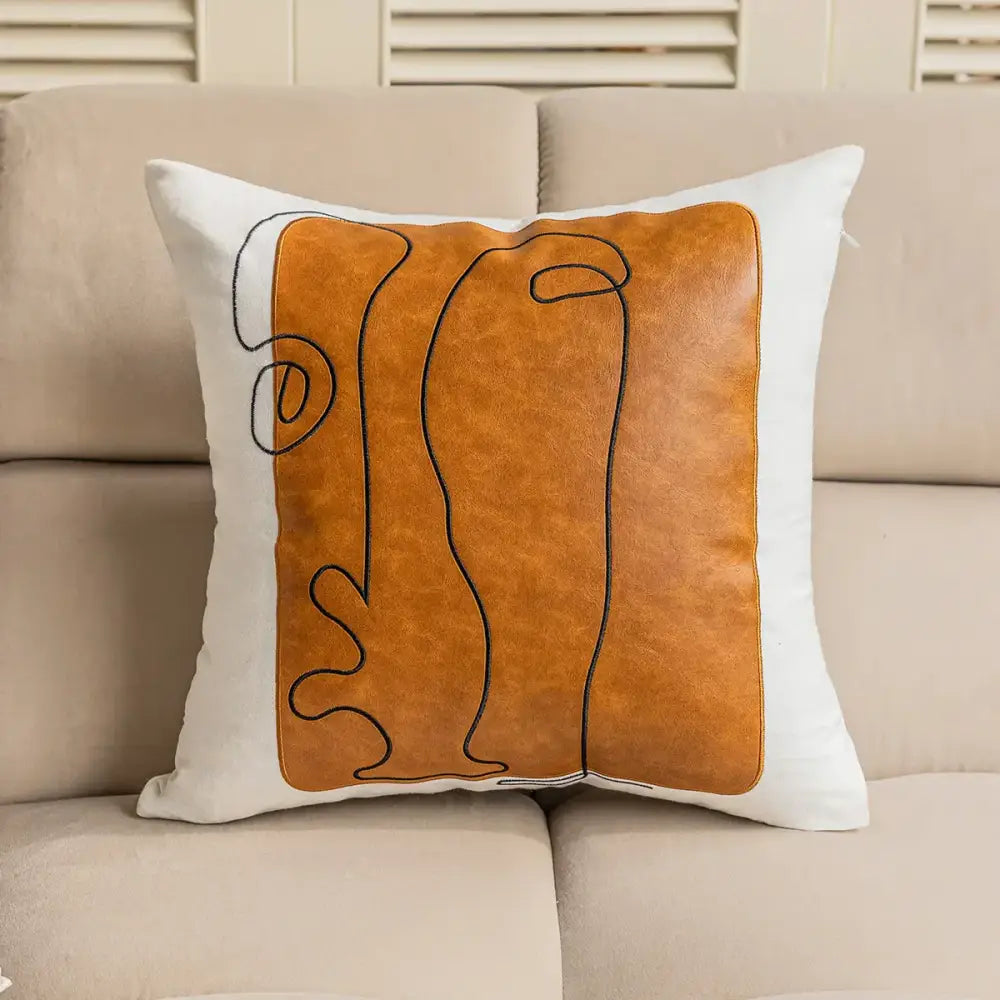 Brown and white plush cushion cover with orange faux leather panel and black geometric embroidery for living room