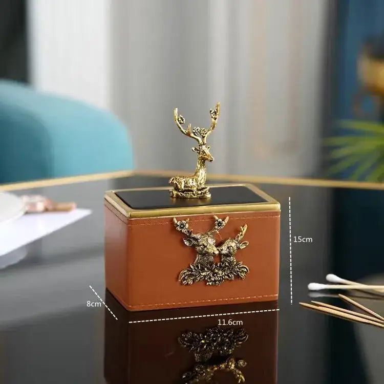Brown leather desktop storage basket with gold deer figurine and metal appliques featuring a black lid for office use