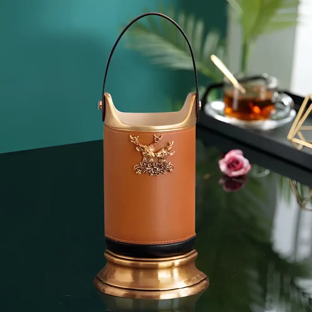 Brown leather desktop storage basket with gold-tone metal handle and gold deer emblem for office use