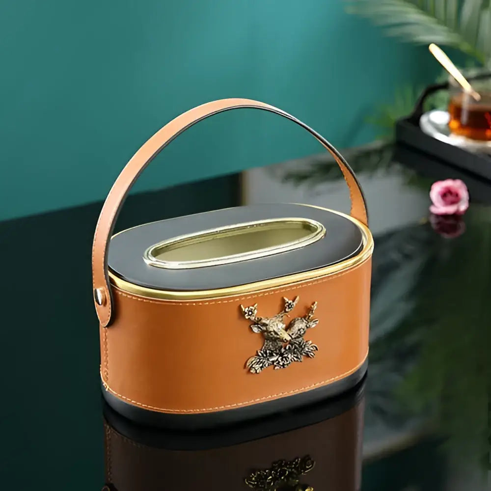 Orange leather tissue box with black lid gold trim and ornate silver deer emblem for desktop storage basket use