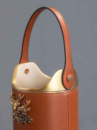 Tan leather desktop storage basket with gold-tone metal handle and decorative stag for office use