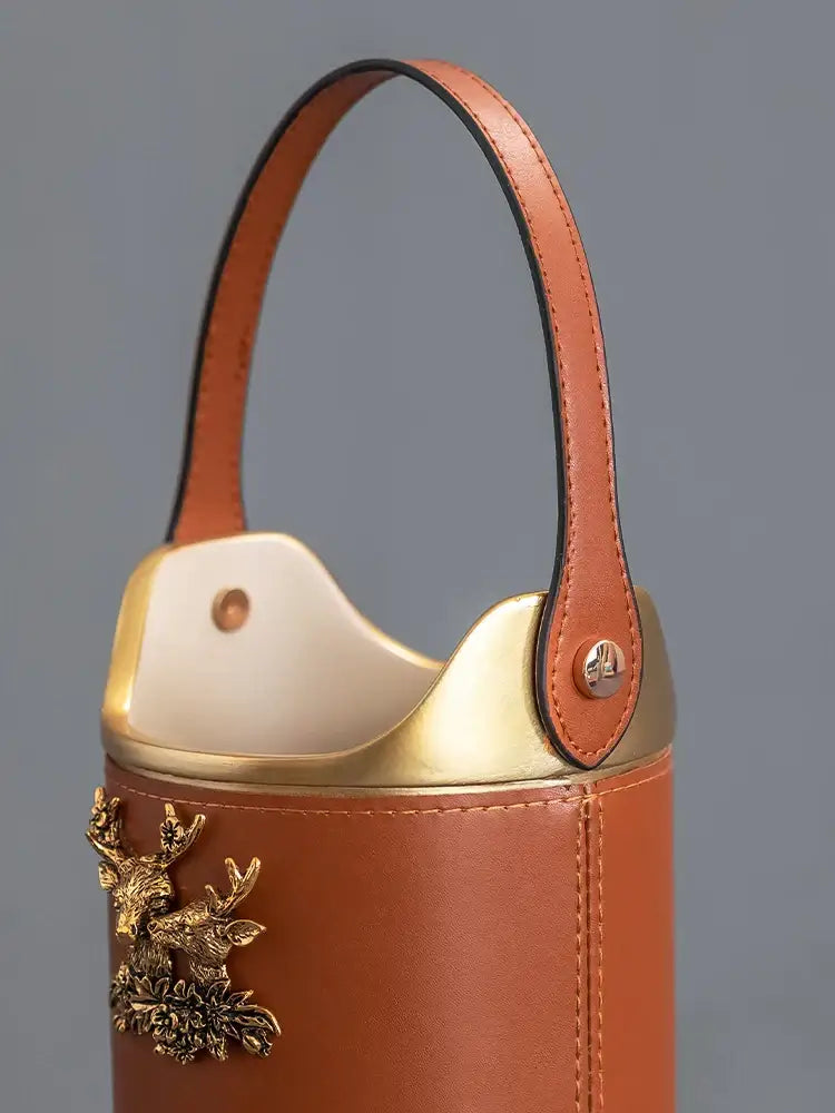 Tan leather desktop storage basket with gold-tone metal handle and decorative stag for office use