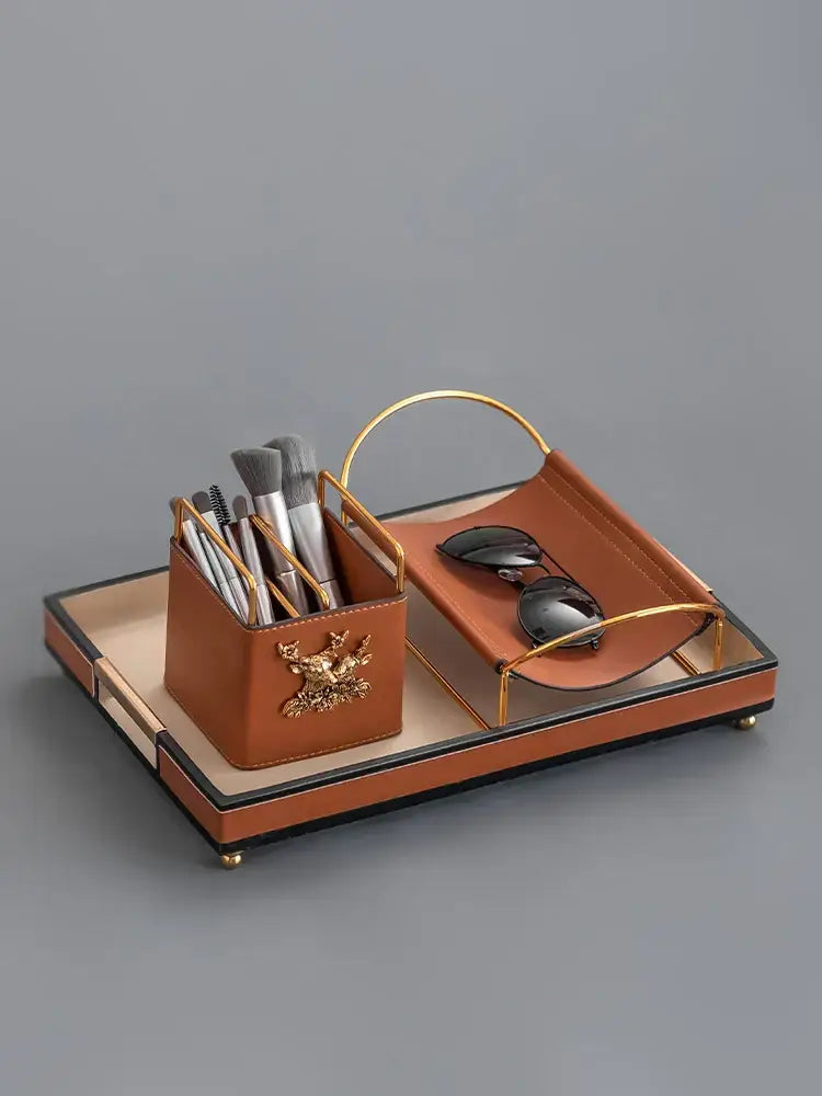 Brown leather desktop storage basket with gold deer and matching tray holding makeup brushes for office use