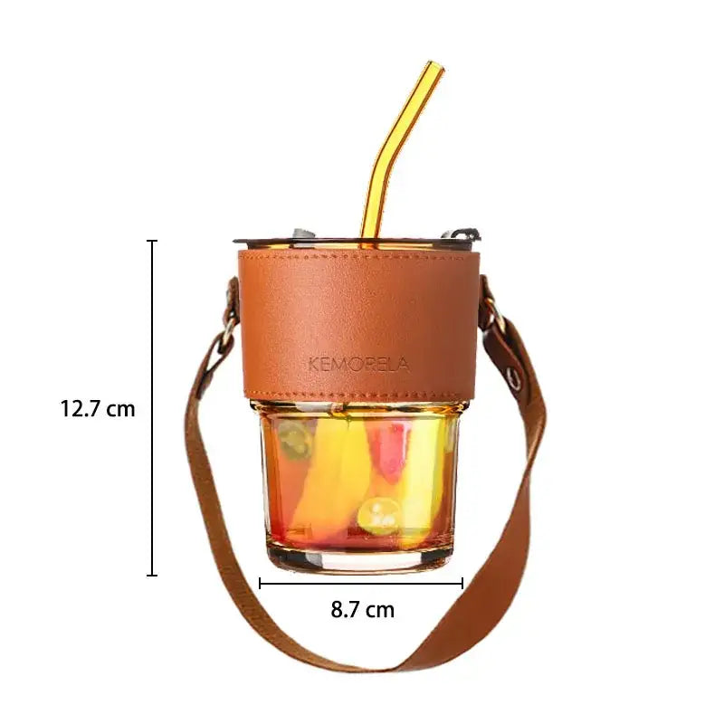Brown leather-wrapped glass coffee cup with gold and yellow straw and adjustable strap branded kemorela