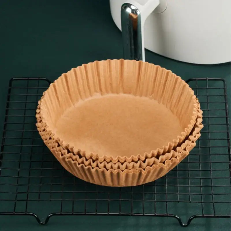 Stack of brown non-stick barbecue paper pie pans with fluted edges for kitchen cooking and baking use
