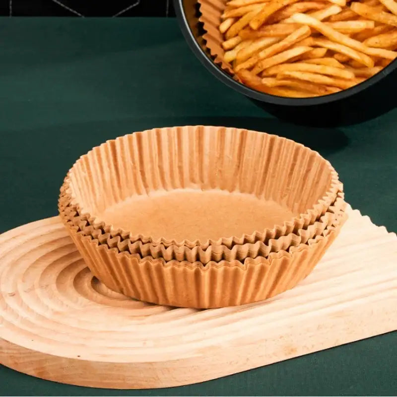 Stack of brown non-stick barbecue paper baking cups with fluted edges for kitchen cooking and baking use