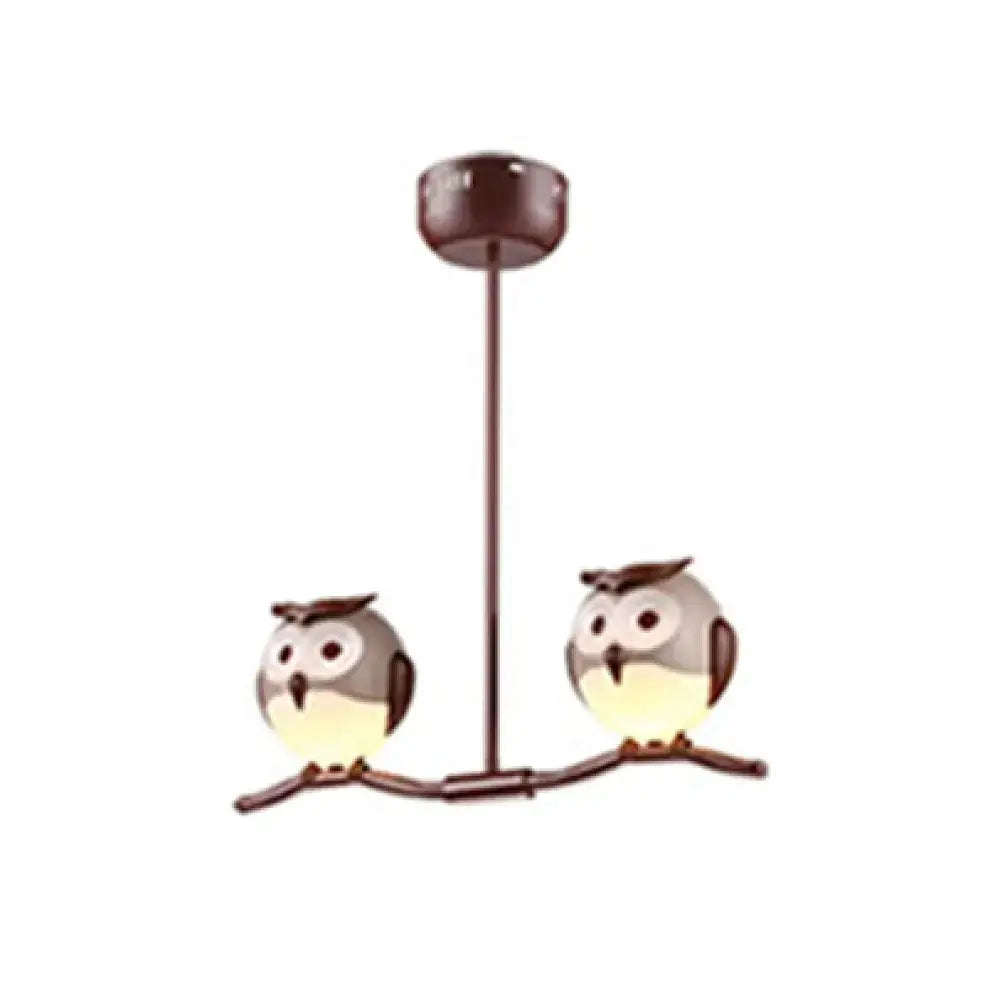 Brown metal pendant light featuring two cartoon owls with glowing yellow underbellies using led incandescent bulbs