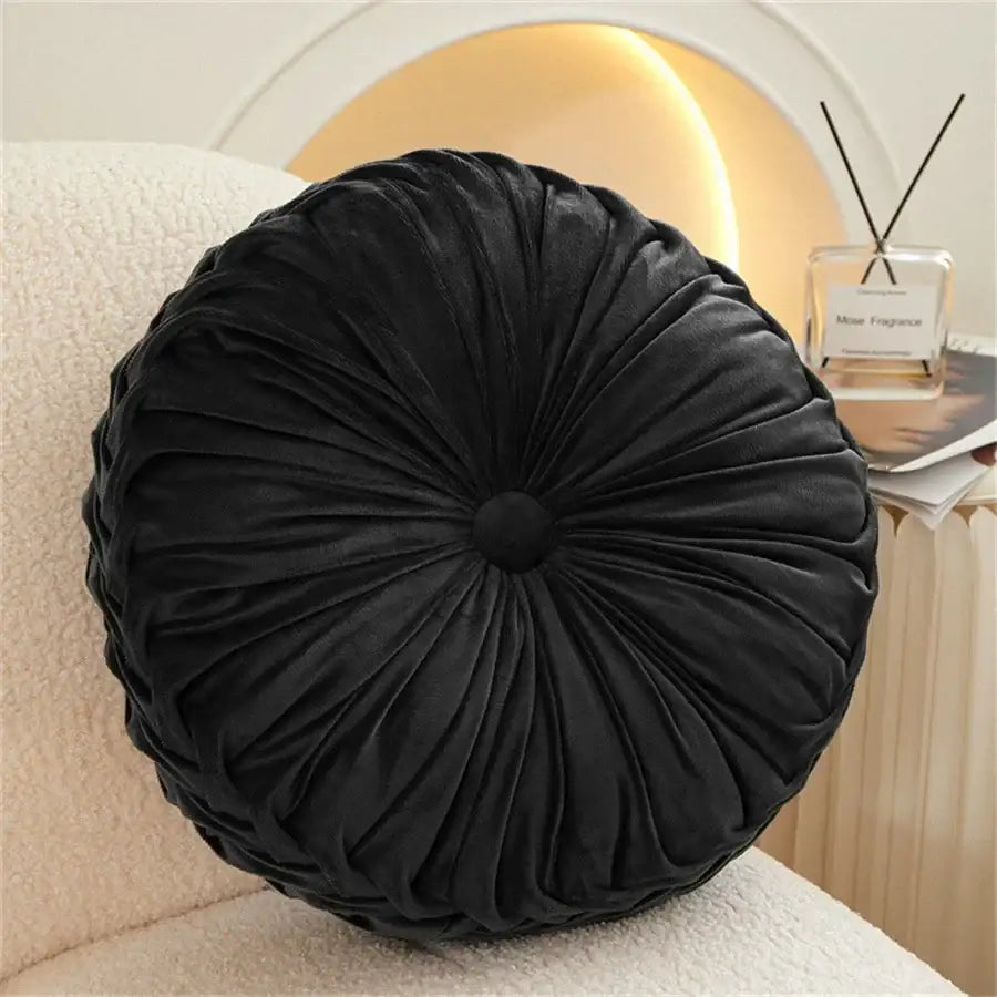 Black velvet round seat cushion with gathered pleated design and central button for living room use