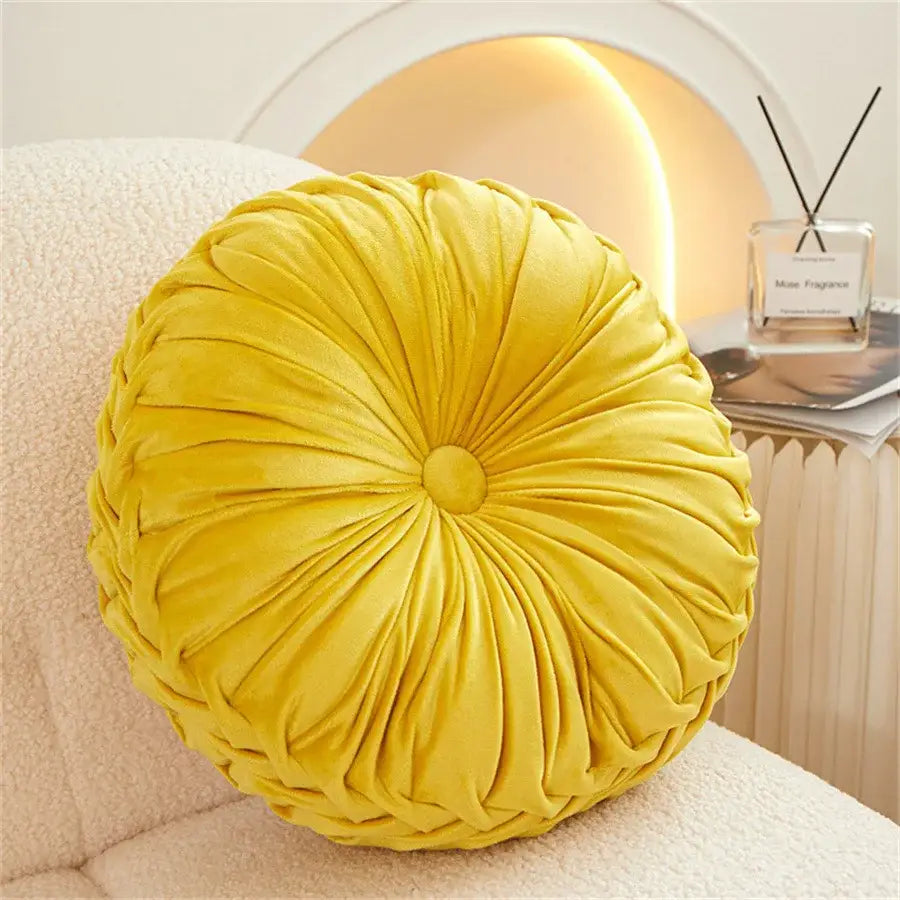 A plush mustard-yellow dutch velvet round seat cushion with pleated radial design for living room use