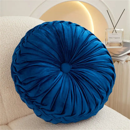 A plush deep blue velvet round seat cushion with gathered center design for living room use