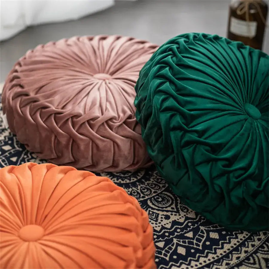 Three round plush velvet round seat cushions in dusty rose emerald green and coral orange with dutch velvet pleats