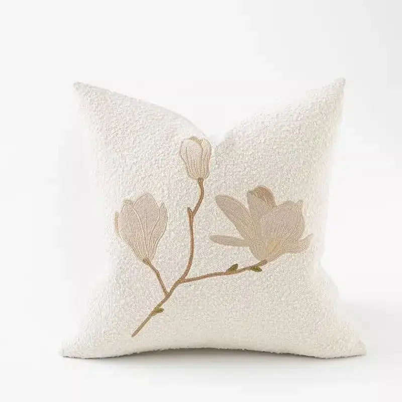 Cream-colored pillow cover with beige and tan embroidered magnolia blossoms in brown and white auspicious clouds jacquard