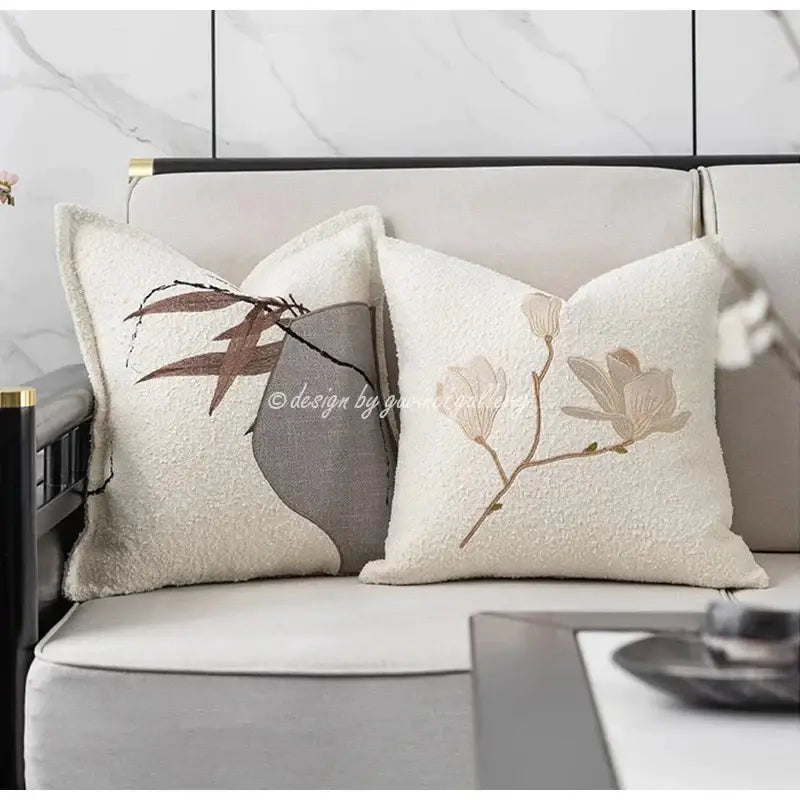 Cream-colored pillow cover with embroidered botanical designs in muted brown and beige featuring auspicious clouds jacquard