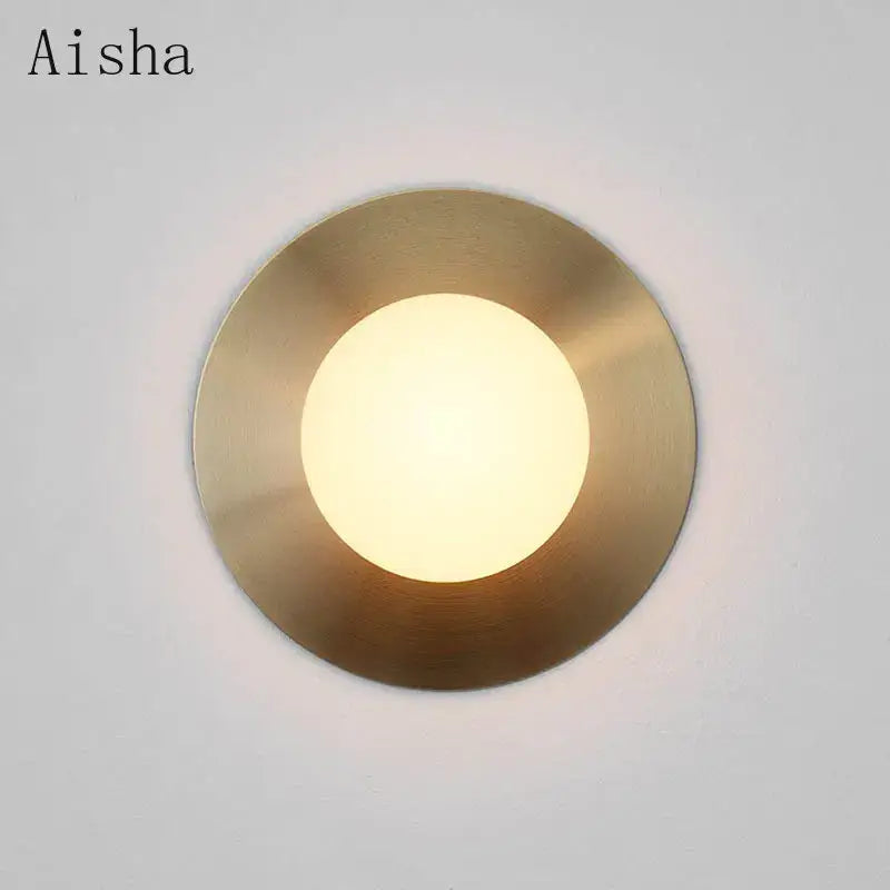 Aisha brand brushed brass circular wall lamp with frosted glass panel providing warm diffused glow for decorbites circular wall lighting