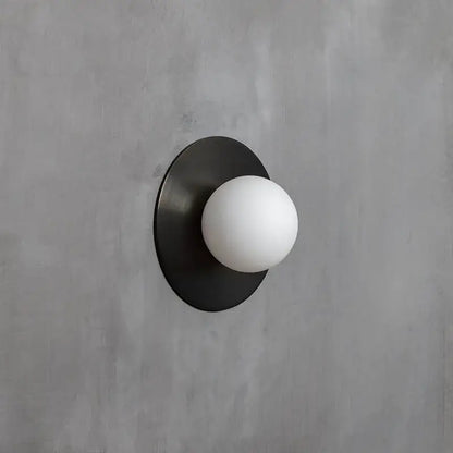 Brushed brass circular wall lamp with black matte finish and white frosted glass globe for bedroom decorbites circular wall
