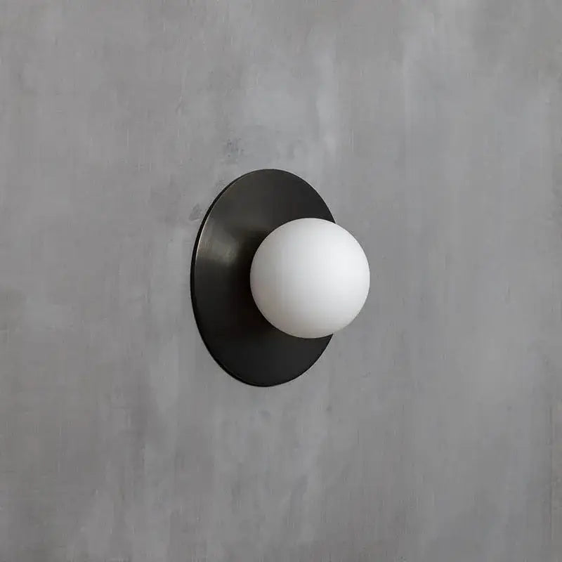 Brushed brass circular wall lamp with black matte finish and white frosted glass globe for bedroom decorbites circular wall