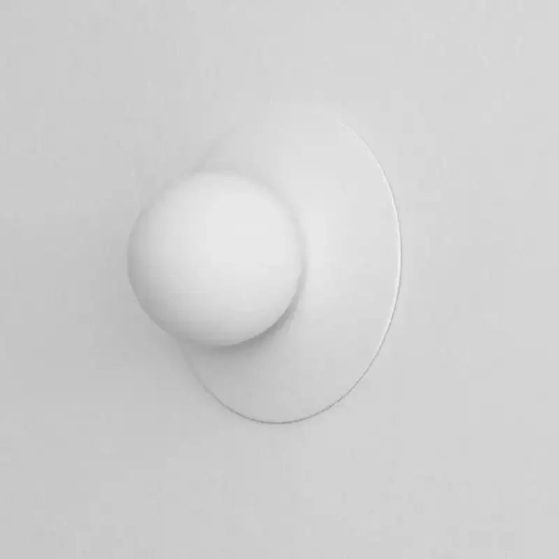 White spherical wall-mounted knob with smooth matte finish on brushed brass circular wall lamp decorbites circular wall lamp