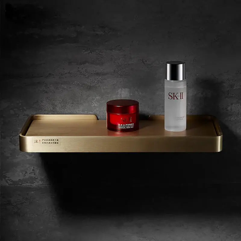 Brushed gold and black corner shelf with gold-toned rectangular tray featuring a matte finish and subtle engraved text