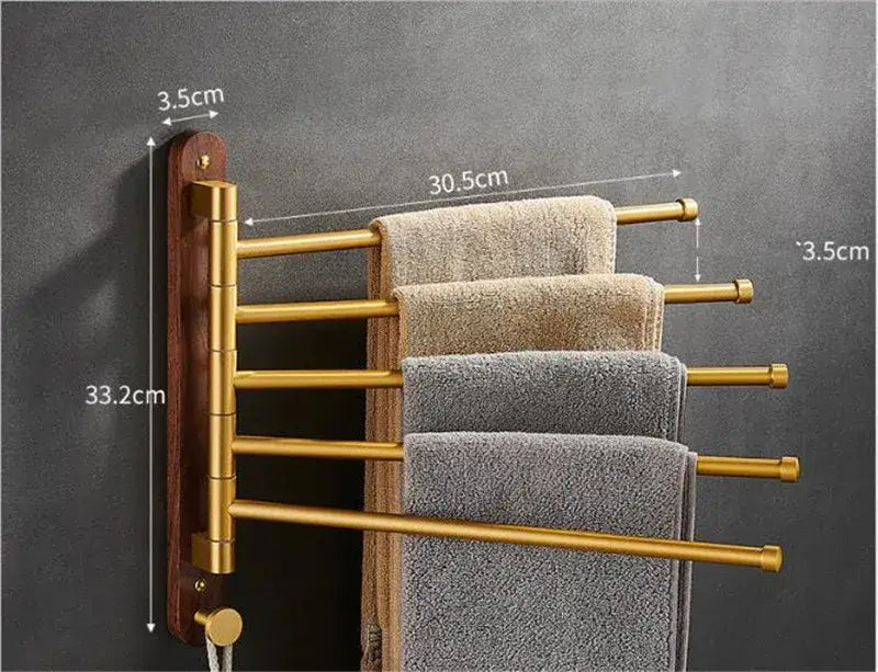 Brushed gold swivel towel hanger with wooden backplate holding neatly folded beige and gray towels