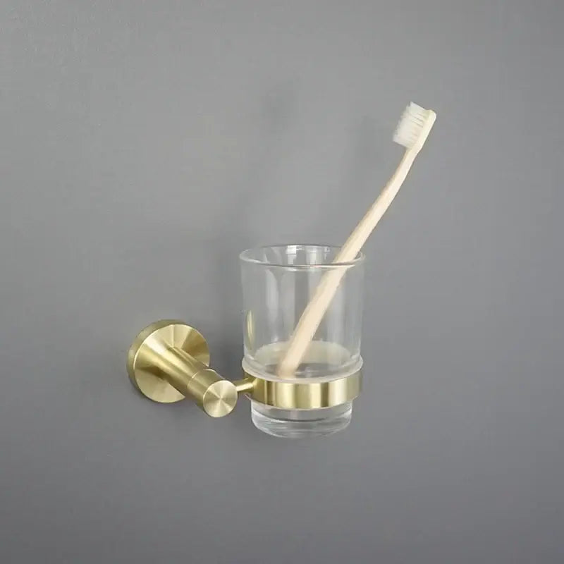 Brushed gold bathroom pendant wall-mounted toothbrush holder with clear glass cup and brass accents by decorbites