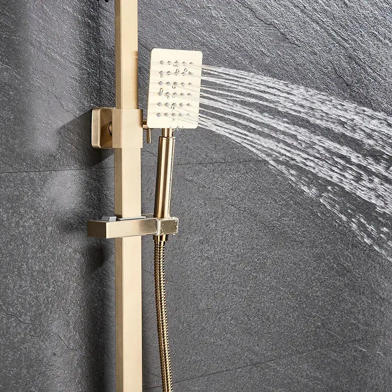 Brushed gold shower mixer with a gold-toned rectangular rainfall head and handheld spray mounted on a vertical rail system