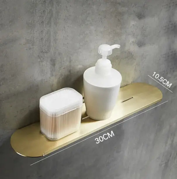 Brushed gold stainless steel bathroom storage rack with mirror front holding a white pump and cotton swabs container