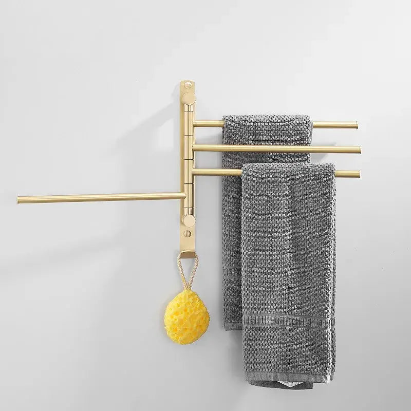 Brushed gold wall-mounted towel hanger with three horizontal bars holding gray towels and a yellow sponge decorbites brushed gold