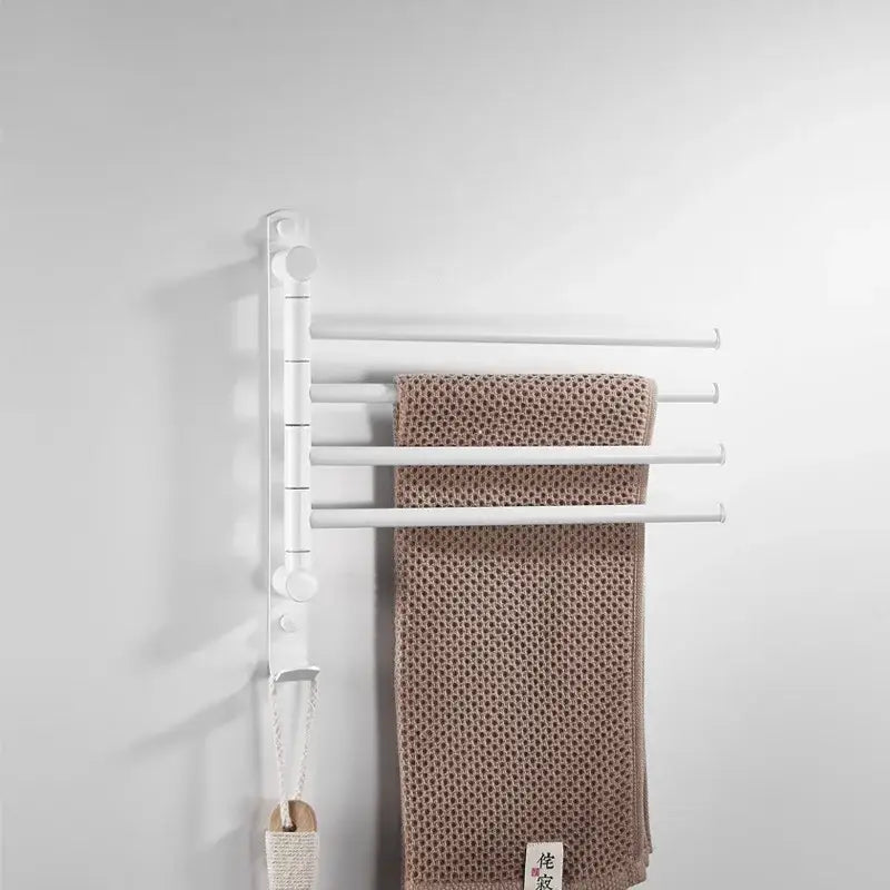 White wall-mounted towel hanger with four bars holding a beige towel for decorbites brushed gold swivel triple arm rack